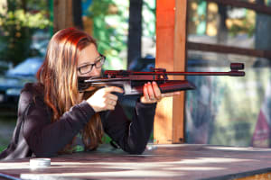 An attractive woman shoots an air rifle