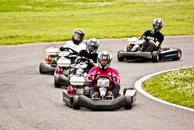 A group of guys racing go karts around a track