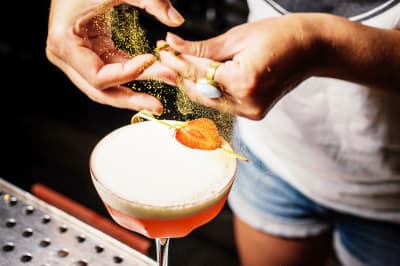A woman pouring a cocktail during a cocktail making class