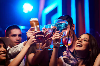 Group of Young and Friendly People Toasting in Nightclub