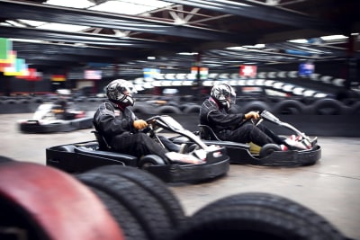 Go karts racing around a track flip image