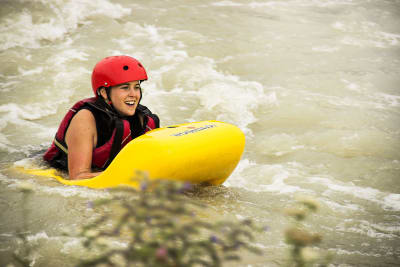 A woman going down the rapids on a hydro speed