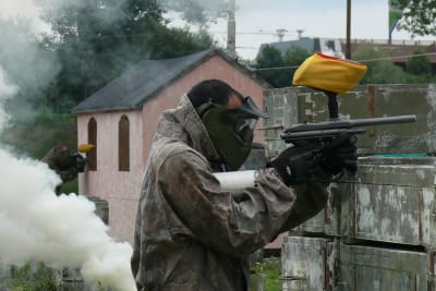 Two men playing paintball with smoke grenade