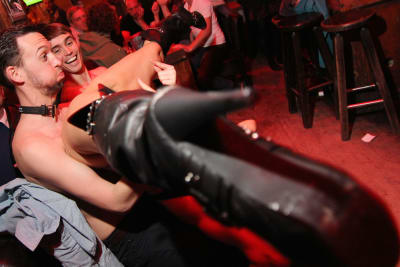 A man with a stripper on his lap during a strip dinner