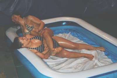 Two wrestling babes wrestling in a pool