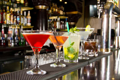 a selection of cocktails and drinks on a bar