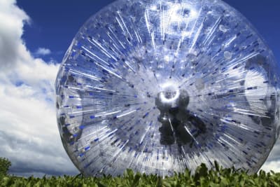 An image of a person rolling down a hill in a zorb ball